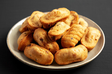Homemade Chocolate Chips Madeleines on a Plate on a black background, side view. Close-up.