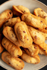 Homemade Chocolate Chips Madeleines on a Plate on a black background, top view. Flat lay, overhead, from above. Close-up.