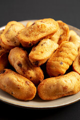 Homemade Chocolate Chips Madeleines on a Plate on a black background, side view. Close-up.