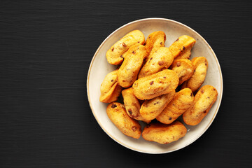 Homemade Chocolate Chips Madeleines on a Plate on a black background, top view. Flat lay, overhead, from above. Copy space.