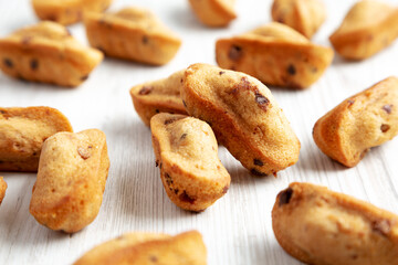 Homemade Chocolate Chips Madeleines on a white wooden background, side view.