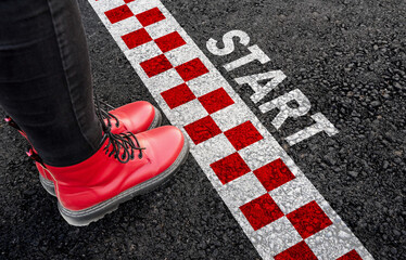 Start. Woman legs in boots standing next to Start line racing
