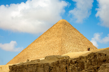Fototapeta na wymiar View of the Egyptian pyramid on a background of blue sky with clouds. Giza. Cairo, Egypt, Africa