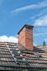 old chimney with wooden ladder on roof