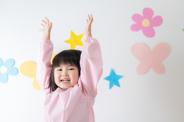手を挙げる笑顔の園児（子供・育児・子育て・保育園・幼稚園） - obrazy, fototapety, plakaty