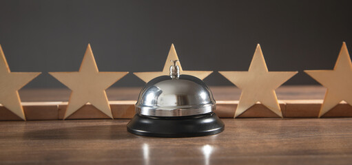 Service bell and wooden 5 stars on the wooden table.