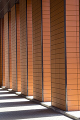 Columns of red tiles cast shadows