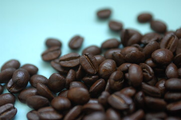 香ばしく美味しい香り高いコーヒー豆が青緑の背景に。カフェで珈琲で一服。