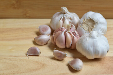 Garlic bulbs on wood background, close-up. Organic garlic top view. Food background. Selective focus. Concept of spices for healthy cooking.