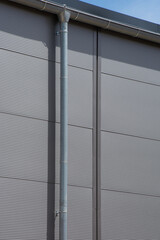 laterally attached gutter on the facade of a large gray warehouse