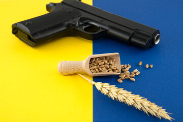 Gun alongside wooden scoop with wheat grain seeds