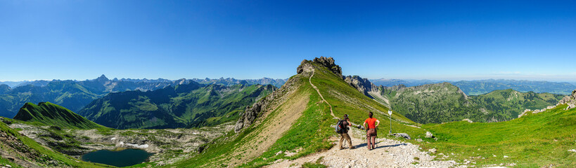 Zwei Wanderer genießen den imposanten Ausblick auf die Allgäuer Alpen mit Nebelhorn, Großem Ifen...