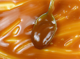 Sweet caramel sauce drop background close up. Golden Butterscotch toffee caramel liquid. 