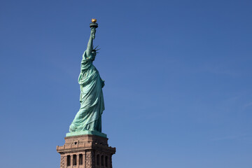 Fototapeta na wymiar Vue sur la statue de la liberté à New York avec en arrière plan un beau ciel bleu de la la place libre pour le texte