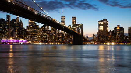 Fototapeta na wymiar vue panoramique en pause longue sur Manhattan et le pont de Brooklyn le soir juste avant la nuit. Buildings et skyline illuminés