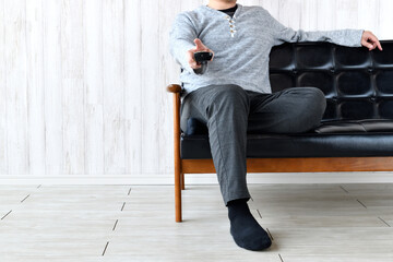 テレビのチャンネルを変える男性