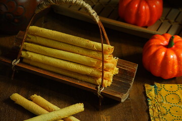 a plate of pumpkin egg roll cookies in dark background