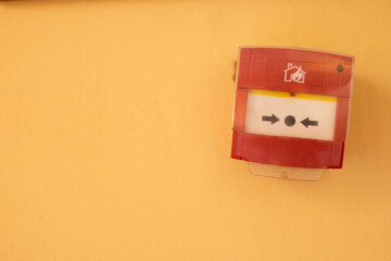 Fire alarm system button on a yellow wall. Copy space.
