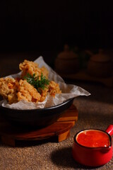 a bowl of fried chicken in dark background