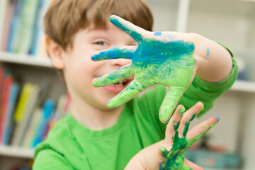 Little pre-school artist. Boy with painted hands hiding his eyes. Important international symbols:...