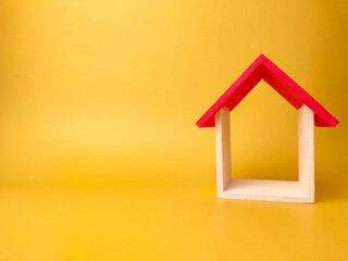 Toy house isolated on yellow background with copy space