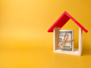 Fototapeta na wymiar Toy house and banknotes isolated on yellow background with copy space