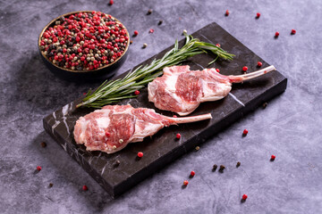 Fototapeta na wymiar Lamb chops on dark background. Raw lamb chops with spices. close up
