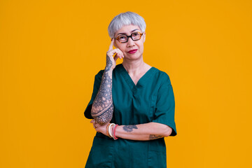 old senior asian female grey hair and tattoo with glasses wear hospital uniform standing with...