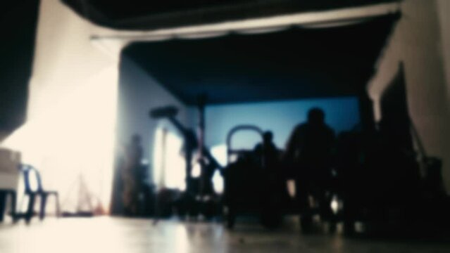 Blurry footage to represent overview working for video production in studio. Behind the scenes of video production. Shooting or filming a movie by director and film crew team with camera lighting set.
