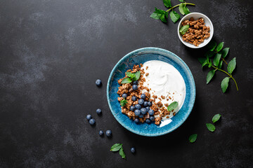 Chocolate granola with white plain yogurt and fresh blueberry in a bowl, healthy food for...