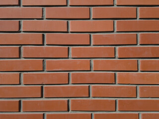 Rough red brick wall, with pieces of cement