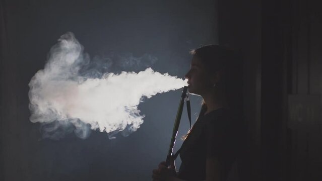 a girl smokes a smoky hookah in a hookah room