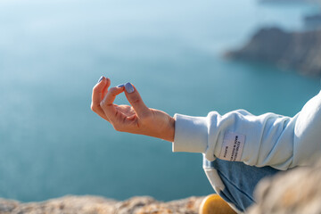 yoga, gesture and healthy lifestyle concept - hand of meditating yogi woman showing gyan mudra over...