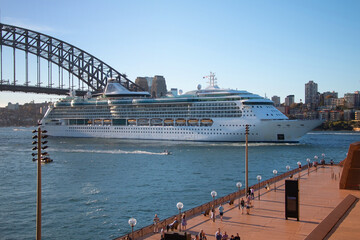 Large cruise ship driving under the bridge over the bay and the embankment, Harbour Bridge, Sydney,...