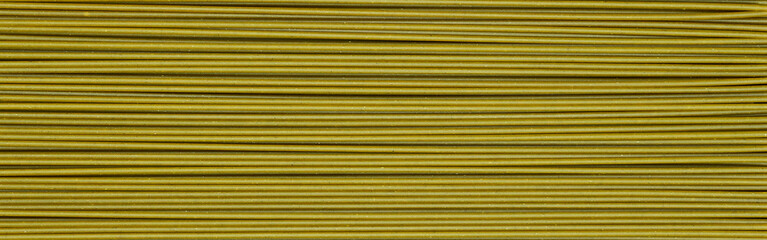 green long raw spaghetti background. spinach noodles