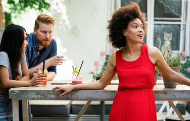 Friends having a great time in cafe, smiling and drinking cocktails enjoying together.