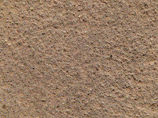 The background texture of the stone is light brown. Macro photography of the surface of a granite stone with a granular structure