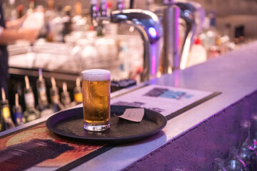 Beer on a tray at a pub in front of tap