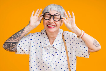 Portrait of attractive funky asian tattoo cheerful grey-haired elder old senior woman touching...