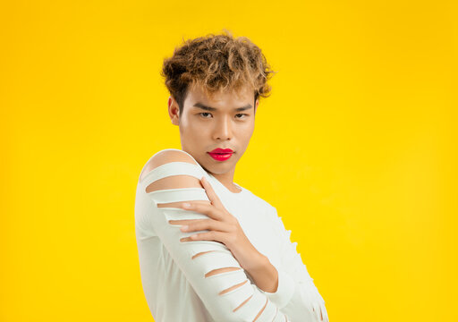 Portrait of a handsome gay man with red lip stick and white shirt. Transgender male looking at camera. LGBTQ+ concept