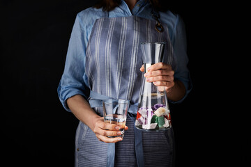 Woman with glass of water and carafe for modern alternative medicine concepts.