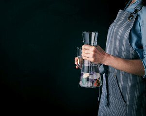Carafe of water and a glass on black background