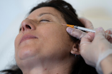 Middle age woman 40s getting lifting botox injection.Cosmetic procedures, Botox injections,...