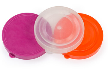 Colored plastic lids for glass jars on a white background