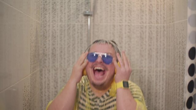 a man dances in the shower and tears off his clothes