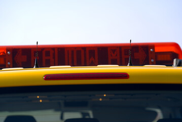 Close-up of roof top with follow me display of parked yellow van of airfield maintenance at Zürich...