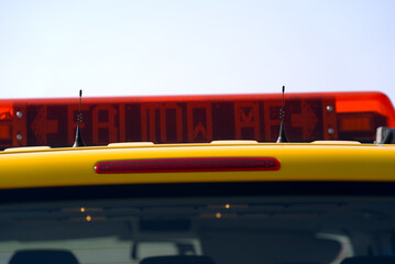 Fototapeta premium Close-up of roof top with follow me display of parked yellow van of airfield maintenance at Zürich Airport on a sunny spring day. Photo taken March 26th, 2022, Zurich, Switzerland.