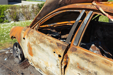 Burnt car with burnt condition in isolation on the side of the road in the wild.