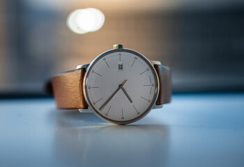 Detail view of classic men wrist watch with white dial and brown leather band