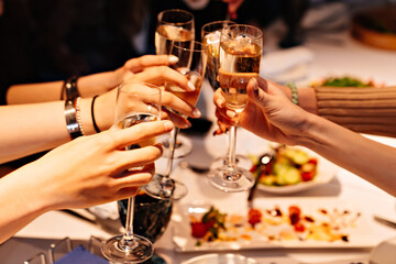hands with glasses of champagne at the banquet. traditional toasts on holidays. 